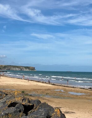 A beach with rocky foreground, waves, and people. - Pretty stone house, 3 bedrooms, 2 bathrooms with a large enclosed garden (Longues-sur-Mer)