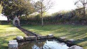 A stone bridge over a small pond with surrounding grass and trees. - 70m² OCEAN, QUIBERON BAY, 12 BEACHES within a radius of 3km  (Plouharnel)
