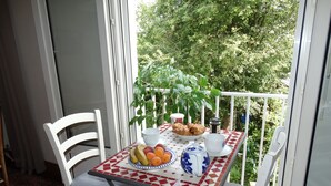 A small balcony with a table set for breakfast, including fruits, pastries, and a cup of coffee. - 70m² OCEAN, QUIBERON BAY, 12 BEACHES within a radius of 3km  (Plouharnel)