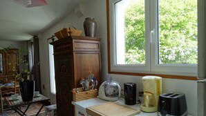 A kitchen with a window, wooden cabinets, a countertop, and various kitchen appliances. - 70m² OCEAN, QUIBERON BAY, 12 BEACHES within a radius of 3km  (Plouharnel)