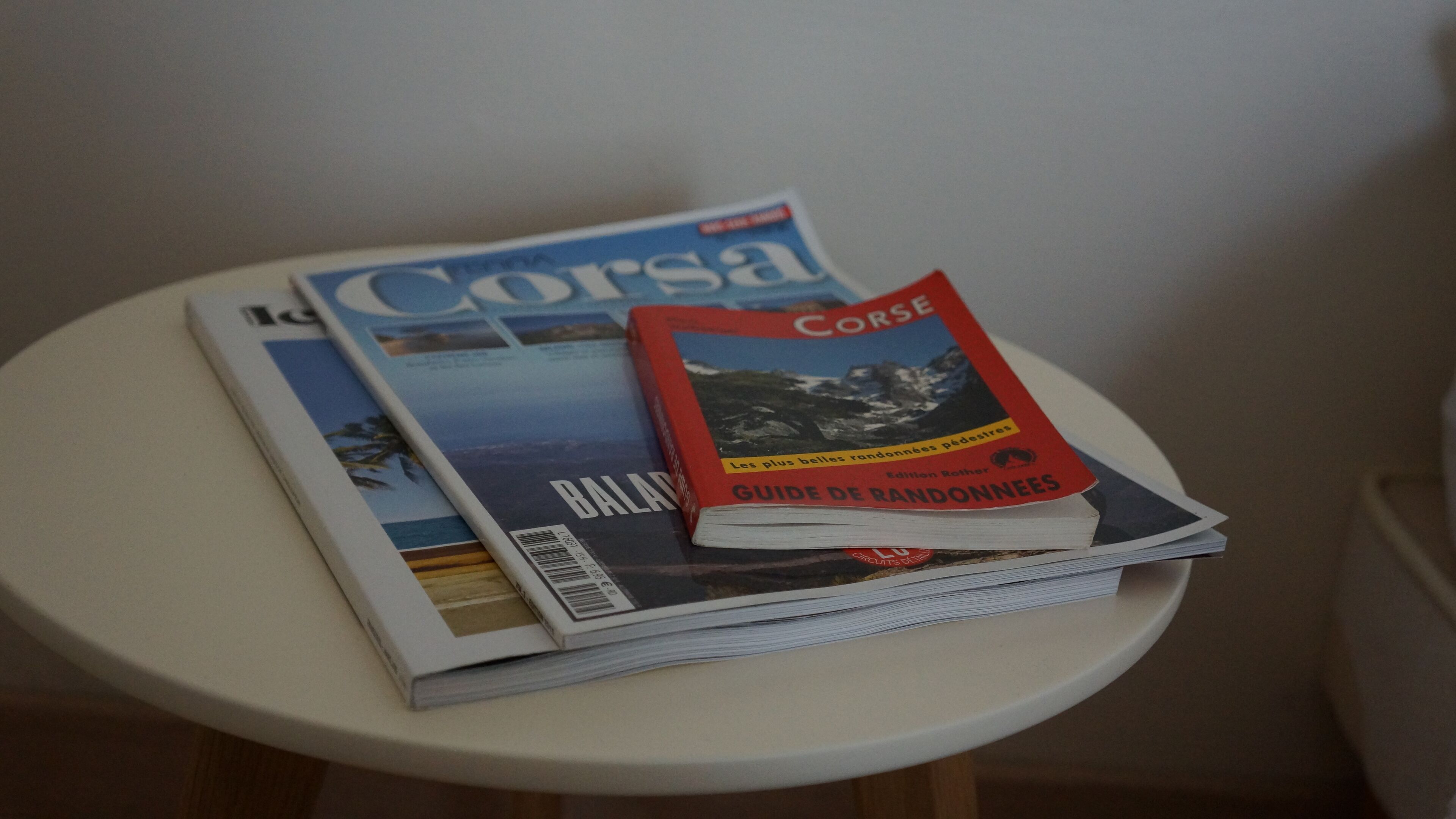 A stack of magazines on a small round table.