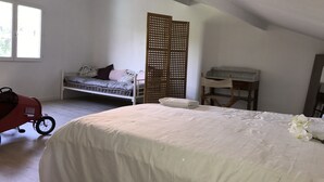Une chambre avec un lit superposé, un bureau et une poussette.