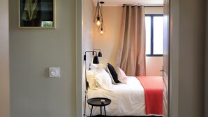 Une chambre à coucher avec un lit, une table de chevet et un luminaire suspendu.