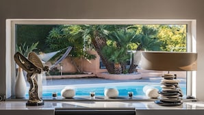 A view of a swimming pool with palm trees and a hammock outside a window. - ★ House with Panoramic Sea View ★ (Théoule-sur-Mer)