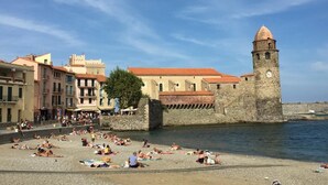 A coastal town with a historic tower and colorful buildings.