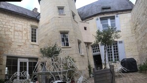 Ein Innenhof mit Steinbauten, Metallgittern und Blumentöpfen.