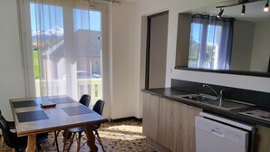 Een moderne keuken met een eethoek, een vaatwasser en uitzicht op de omgeving.