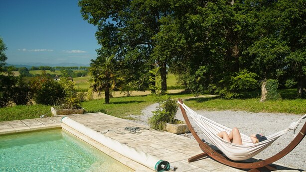 A hammock by a pool with a view of a rural landscape. - Maison De La Residence Celeste (Ogenne-Camptort)