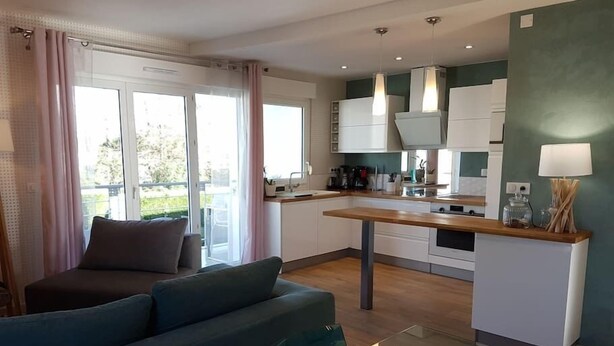 A modern apartment with a living area, kitchen, and dining space.