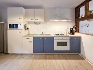 A compact kitchen with a microwave, sink, stove, and cabinets. - Rempart - Large studio in the centre of the village (Eguisheim)