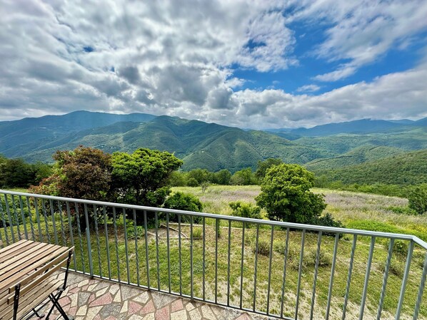 A balcony with a view of green hills and a cloudy sky. - nature and change of scenery (Montferrer)