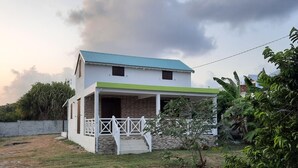 Une maison à deux étages, dotée d’un toit végétalisé et d’un porche abrité.