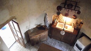 Una cocina pequeña con una mesa de madera, un fregadero y un colgador para ollas.