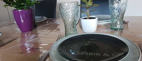 A dining table set with a plate, cutlery, and two glass vases.