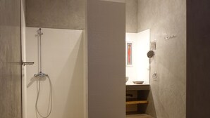 Een moderne badkamer met een douche, een wastafel en een toilet.