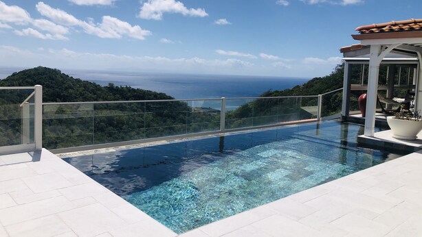 A clear blue sky with clouds, a swimming pool with clear water, and a view of the sea and greenery in the background. - Very beautiful luxury villa (Sainte-Luce)