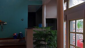 A spacious interior with a high ceiling, a staircase leading to an upper level, and a large window providing a view of the outside. - Very beautiful luxury villa (Sainte-Luce)
