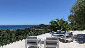 An outdoor patio with white furniture and a view of the sea. - Superb villa with panoramic sea view Sainte Maxime (Sainte-Maxime)