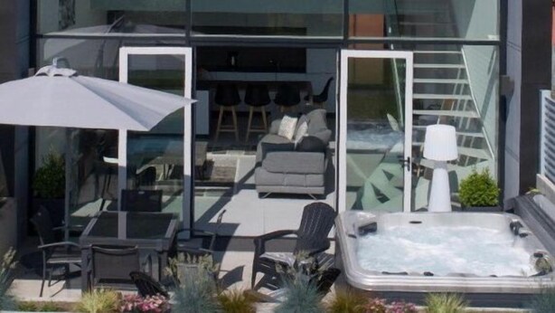 A modern house with large glass windows, a patio with outdoor furniture, and a hot tub. - Maison D'Architecte in one of France's most beautiful villages (Bergheim)