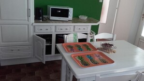 A kitchen with white cabinets, a microwave, and a table with a pineapple-themed tray. - LARGE COUNTRY HOUSE in the South Luberon (Cabrières d Aigues)