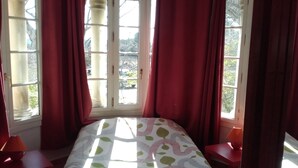 A room with a bed, two nightstands, and a window with curtains. - LARGE COUNTRY HOUSE in the South Luberon (Cabrières d Aigues)