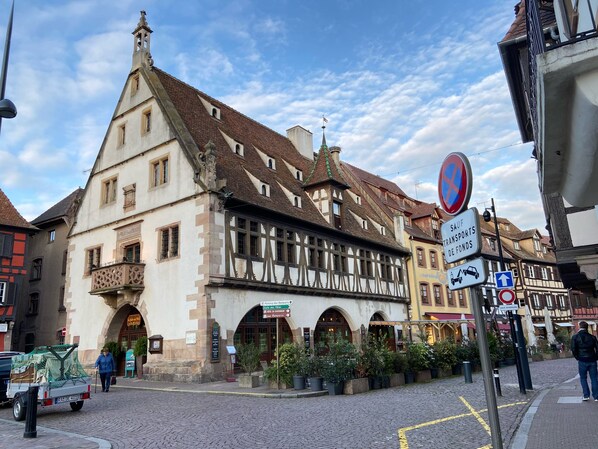 A traditional European building with a gabled roof, a balcony with intricate latticework, and a sign indicating parking availability. - Apartment and garden in house in Obernai (Obernai)