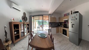 Een moderne keuken met een eettafel, kasten en een koelkast.