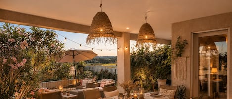 An outdoor dining area with a round table set for four, surrounded by chairs.