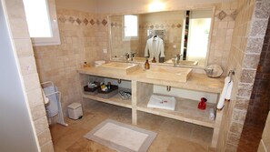 Une salle de bain avec deux lavabos, un miroir et un porte-serviettes.