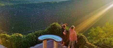 A scenic overlook with a curved viewing platform and a metal railing.