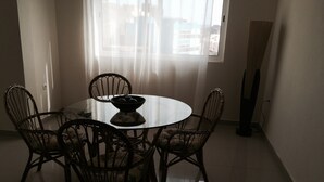 A dining area with a round table, six chairs, and a bowl on the table. - Apartment for rent. on the island of Sao Vicenter Mindelo near the beach (Mindello)