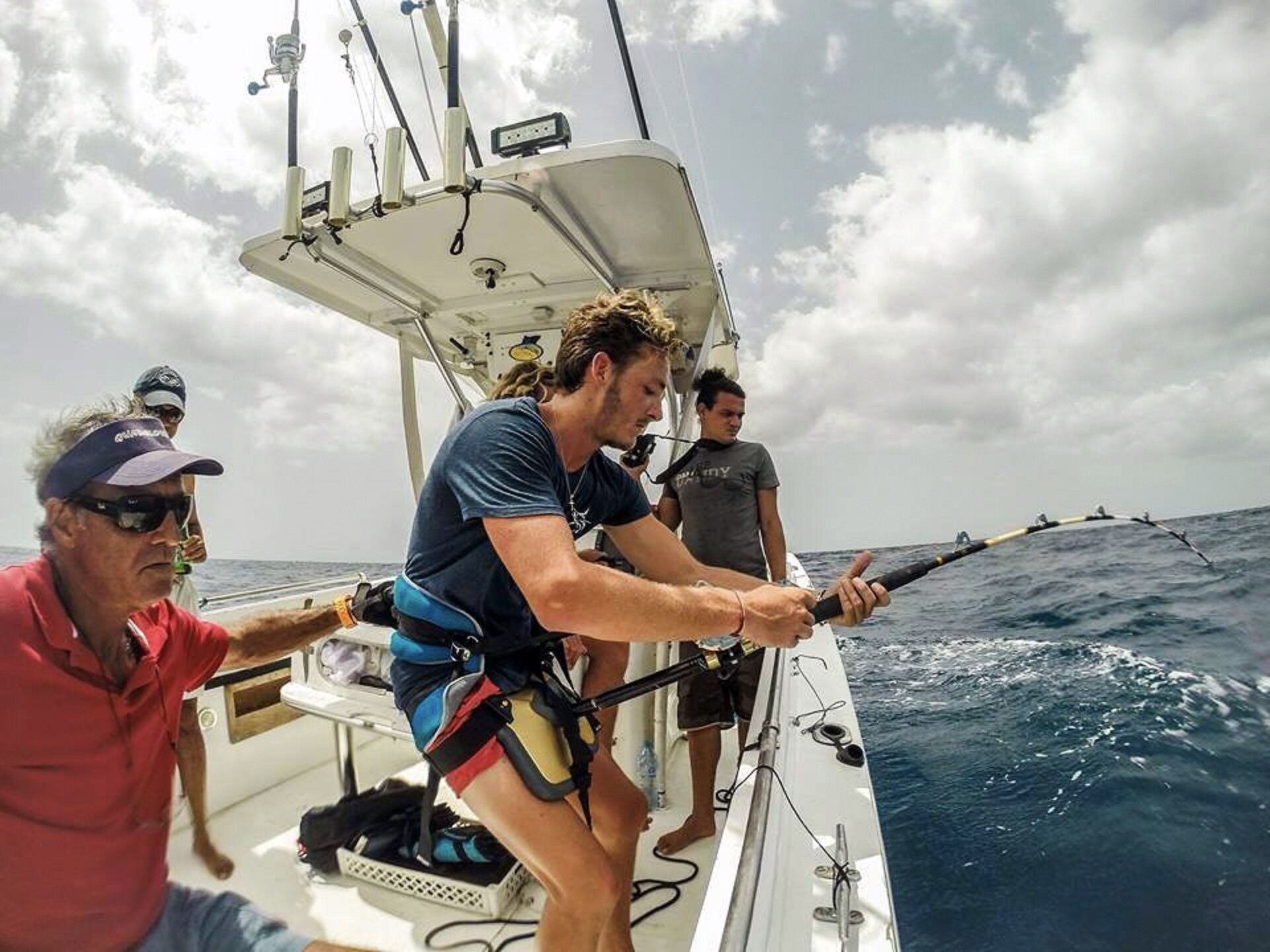 Une personne à bord d’un bateau, portant un gilet de sauvetage et tenant une corde.