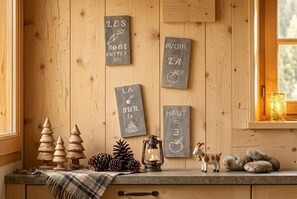 A wooden interior with a rustic kitchen counter, wooden cabinets, and a window with a view. - Spacious 3-room apartment in the center of the village (Cauterets)