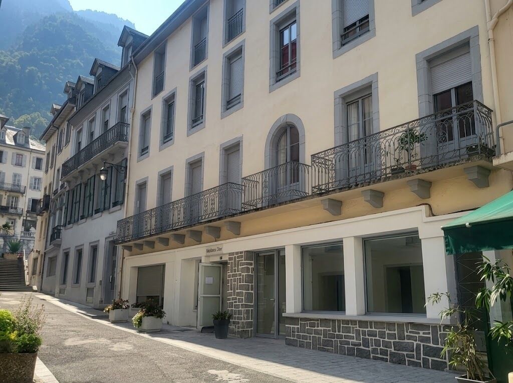 Hotel amb façana de pedra, diversos balcons i vistes a les muntanyes.