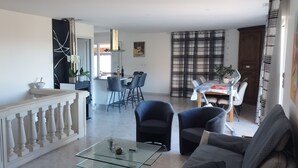 A modern living room with a glass coffee table, a sofa, and a dining area with a table and chairs. - 110 m² villa with a pool and breathtaking views, not overlooked. (La Motte)