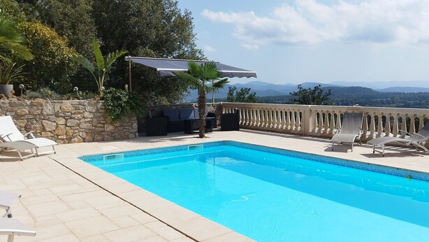 A swimming pool with lounge chairs and a pergola, surrounded by a stone wall and vegetation, with a view of distant mountains. - 110 m² villa with a pool and breathtaking views, not overlooked. (La Motte)