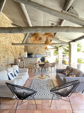 Un'accogliente zona giorno con parete in pietra, soffitto in legno e un set da pranzo.
