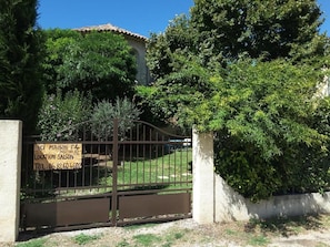 A gated property with a sign indicating 'ICI MAISON F4 PISCINE' and a telephone number.