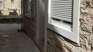 A narrow alleyway with stone walls and a window with white shutters. - PRVINSKI AKVAREL, large renovated fisherman's house adapted for disabled visitors  (Prvić Luka)