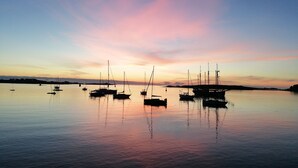 Een rustige haven met verschillende zeilboten afgemeerd bij zonsondergang.