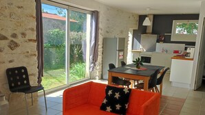 Una sala de estar con un sofá, una mesa de comedor y una cocina al fondo.