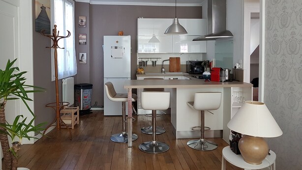 A modern kitchen with a central island, bar stools, and a hanging light fixture. - In the heart of the city center (Blois)