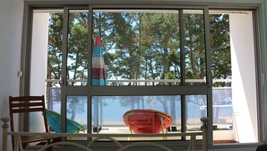A room with a large window, a bed, a wooden chair, and a red chair. - Magnificent sea view in front of the beach at Trez de Bénodet (Bénodet)