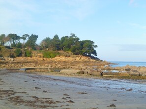 A rocky shoreline with a small pond, trees, and a clear sky. - Beautiful new house with sea view (Saint-Pol-De-Léon)