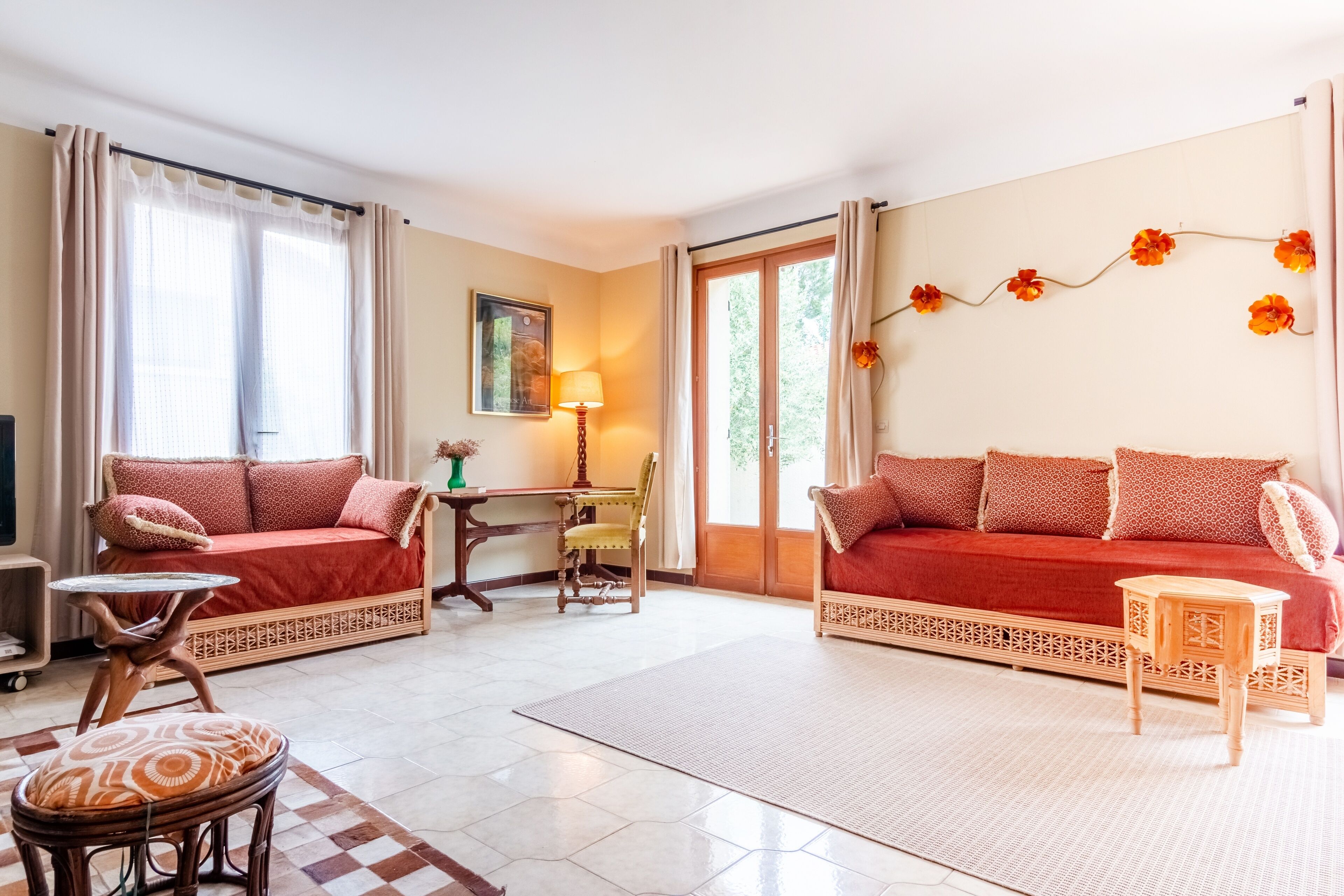 A living room with a red sofa, a wooden chair, a small table, and a lamp.