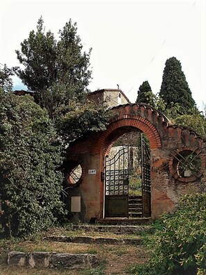 An old brick archway with a metal gate, surrounded by greenery and trees. - House with views, haven of peace, 2 steps from the center of Céret. 4 to 6Pers (Céret)