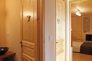 Une porte en bois avec une poignée, un mur blanc et une petite table sur laquelle se trouve un bol.