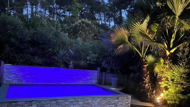 A pool with a stone wall and a wooden deck. - Contemporary villa beach slope privileged site swimming pool (Capbreton)