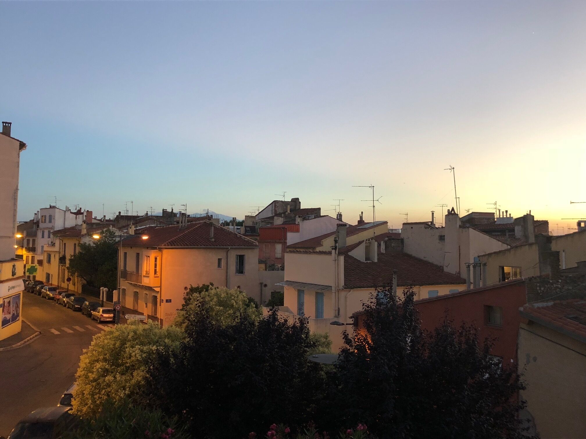 A residential area with houses, a street, and a mountain in the background.