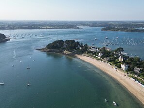 An aerial view of a coastal area with a beach, boats, and buildings. - Villa Ty Marie overlooking the beach, 180° panoramic view (Île-Aux-Moines)
